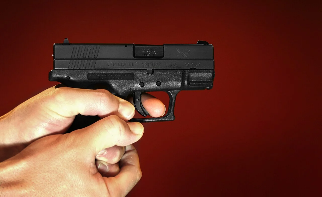 Una pistola semiautomática sobre fondo rojo